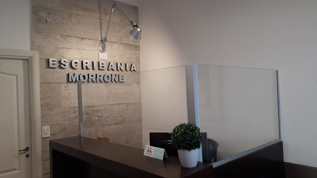 Recepción de la escribanía, con el cartel Escribanía Morrone en la pared y el mostrador de atención